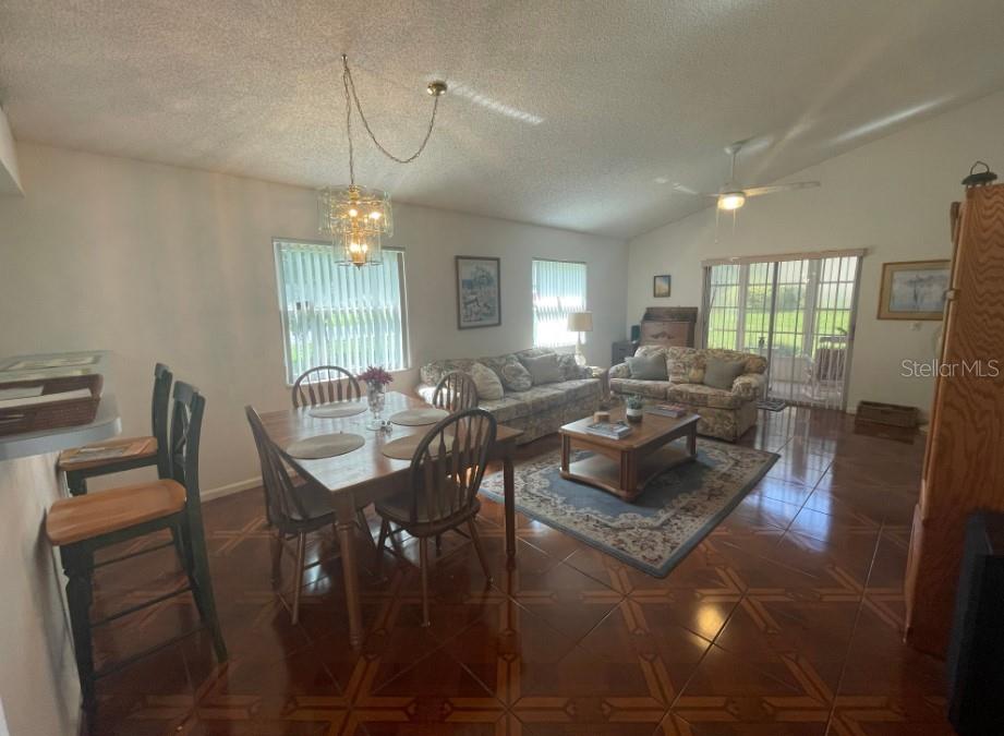 A living and dining area features tile flooring, a wooden table, and a patterned sofa — 5399 NW 18TH STREET, OCALA, FL