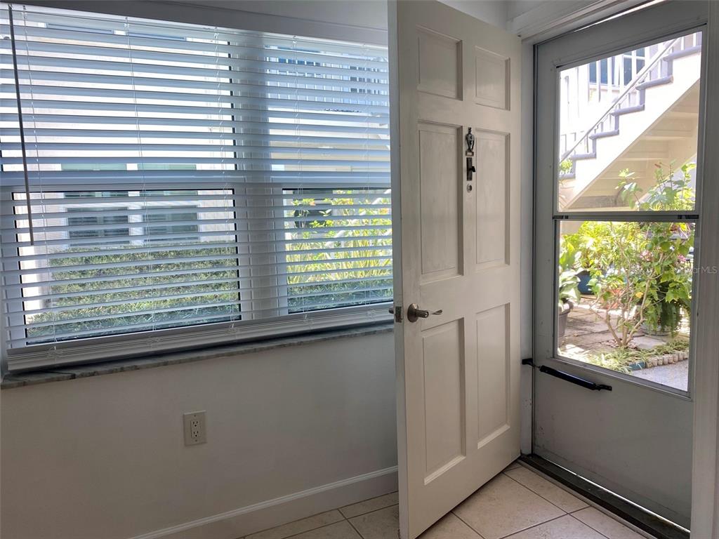 An interior view shows a white door, a window with blinds, and a tiled entryway — 506 71ST AVENUE UNIT 4, ST PETE BEACH, FL