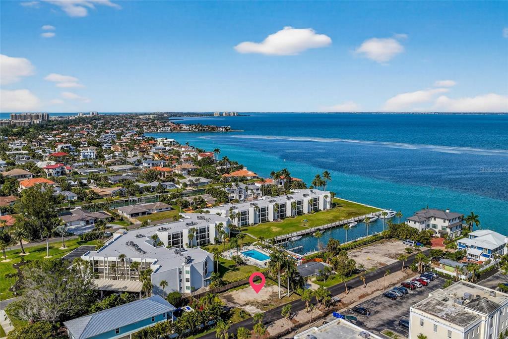 An aerial view shows a vacant lot marked with a pink pin near a waterfront — 525 CHANNEL LANE, LONGBOAT KEY, FL