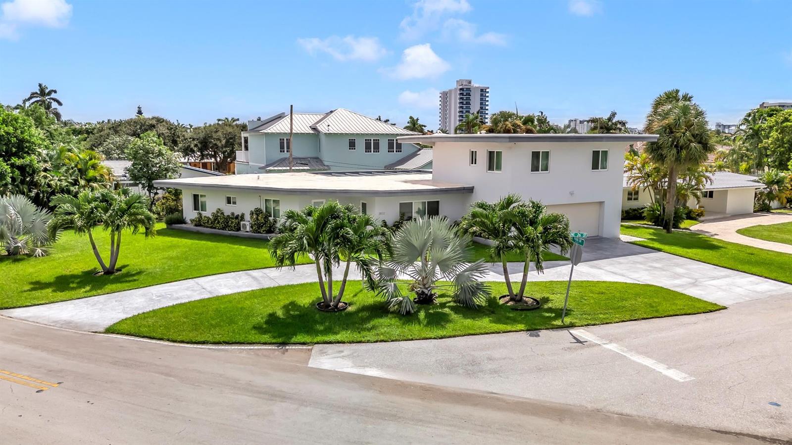 An exterior view of a modern white house with a flat roof and palm trees — 2812 NE 27th Street, Lighthouse Point FL 33064, LIGHTHOUSE POINT, FL