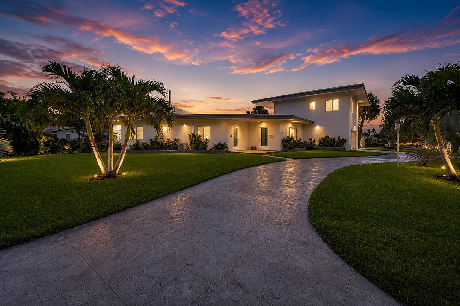 A two-story white house with a curved driveway and palm trees at sunset — 2812 NE 27th Street, Lighthouse Point FL 33064, LIGHTHOUSE POINT, FL