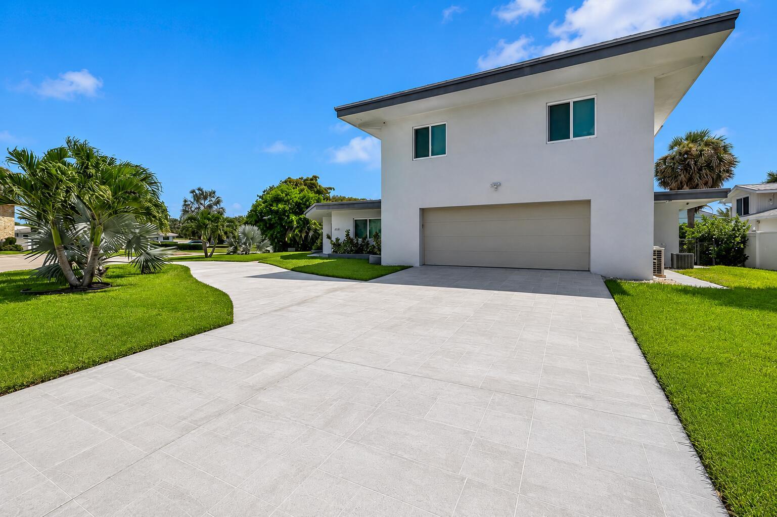 A two-story white house with a tiled driveway and a large garage door — 2812 NE 27th Street, Lighthouse Point FL 33064, LIGHTHOUSE POINT, FL