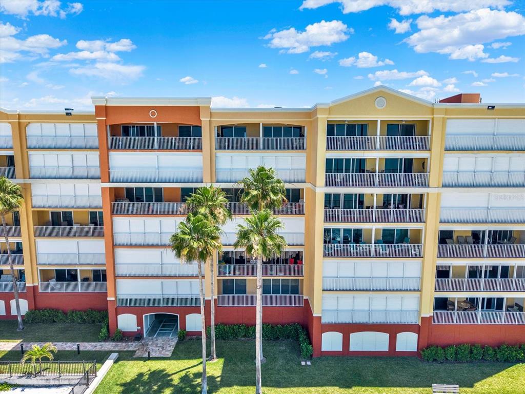 An exterior view of a multi-story apartment building with balconies and palm trees — 16450 GULF BOULEVARD UNIT 763, NORTH REDINGTON BEACH, FL