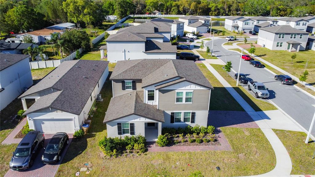An aerial view shows a two-story suburban house with a garage and driveway — 5251 MEREDREW LANE, ST CLOUD, FL