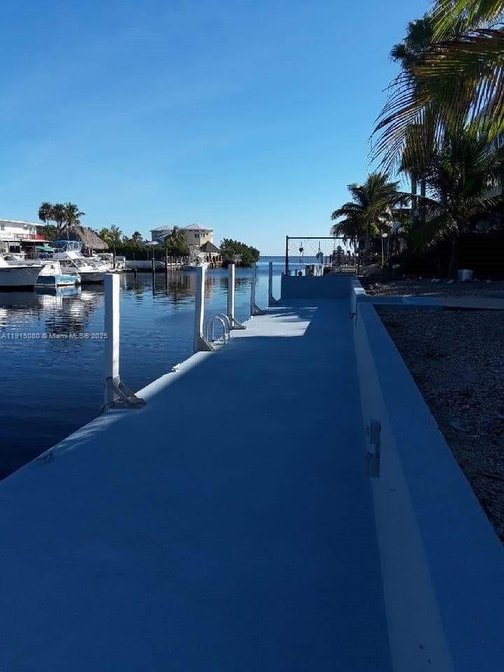 A concrete dock extends along a canal with boats moored in the distance — 26 S Exuma Rd # B, Key Largo FL 33037, KEY LARGO, FL