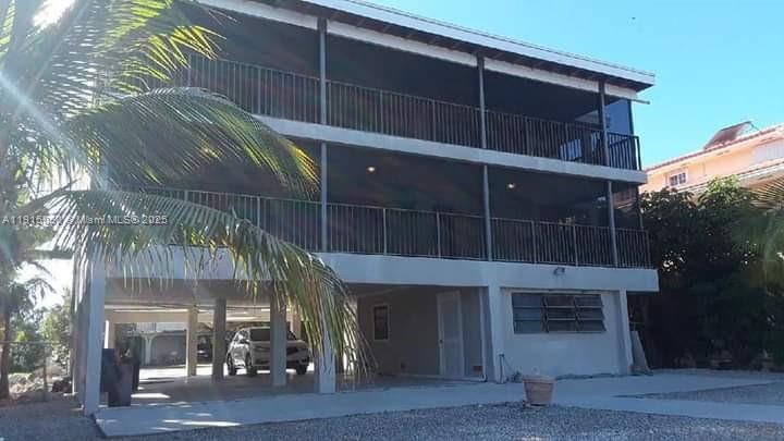 A three-story elevated house with screened balconies and a covered parking area underneath — 26 S Exuma Rd # B, Key Largo FL 33037, KEY LARGO, FL