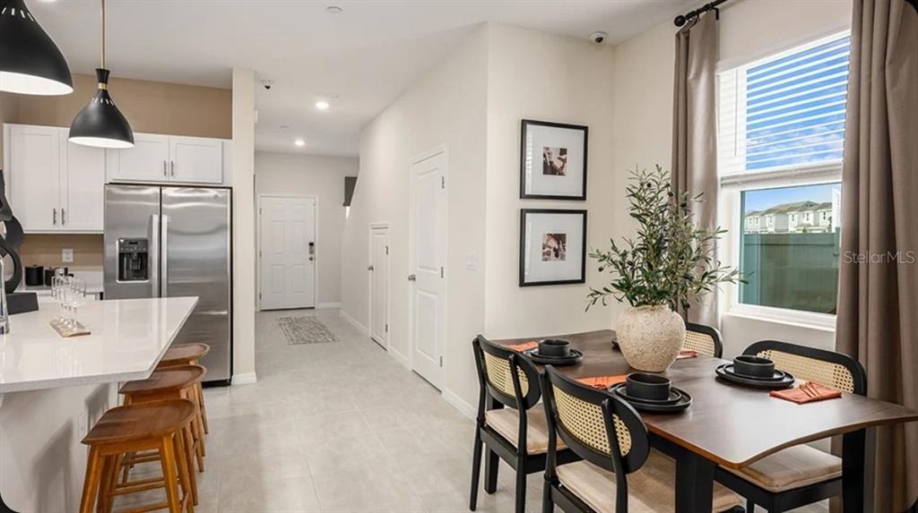 A kitchen with a breakfast bar and dining area featuring a wooden table and chairs — 2631 BALMERINO WAY, MOUNT DORA, FL