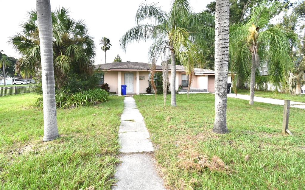A single-story house with a concrete walkway, palm trees, and a lawn in front — 204 SHORE DRIVE W, OLDSMAR, FL