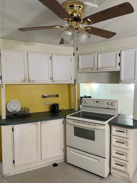 A kitchen features white cabinets, a yellow backsplash, a white stove, and a ceiling fan — 9635 SE 162ND STREET, SUMMERFIELD, FL