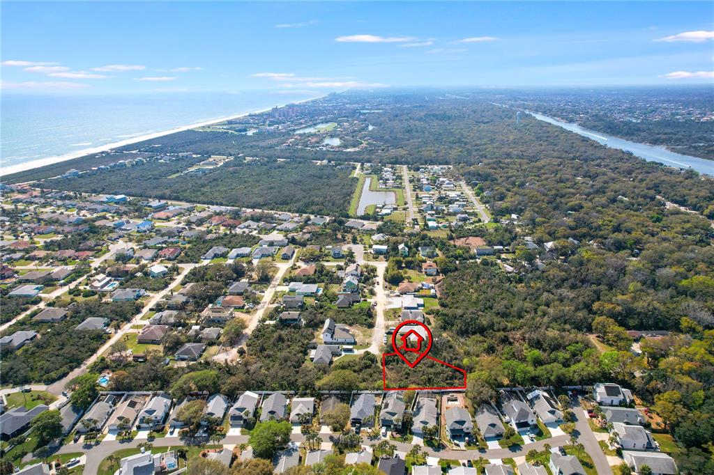 This aerial view shows a vacant, wooded residential lot outlined in red near the coast — 14 SWEETBAY DRIVE, PALM COAST, FL