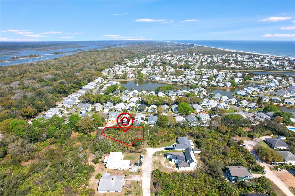 This aerial view shows a vacant, wooded residential lot outlined in red near a coastal community — 14 SWEETBAY DRIVE, PALM COAST, FL