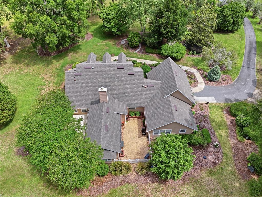 An aerial view shows a house with a gray shingled roof and a central courtyard — 26341 NW 166TH AVENUE, HIGH SPRINGS, FL