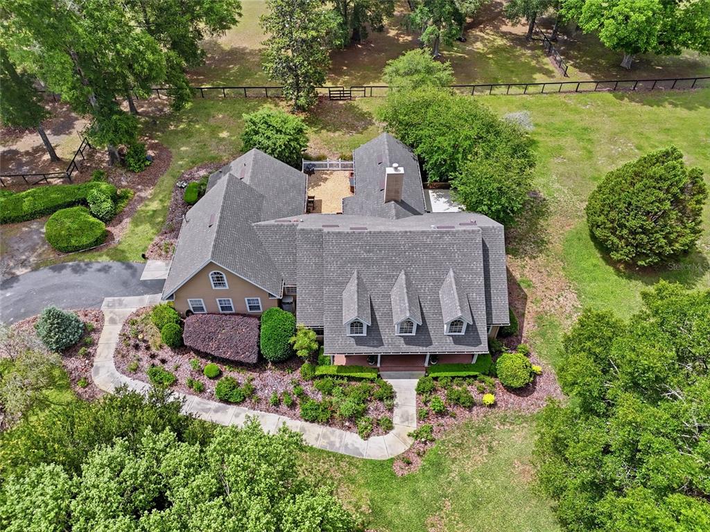 An aerial view shows a tan house with a gray roof and a central courtyard — 26341 NW 166TH AVENUE, HIGH SPRINGS, FL