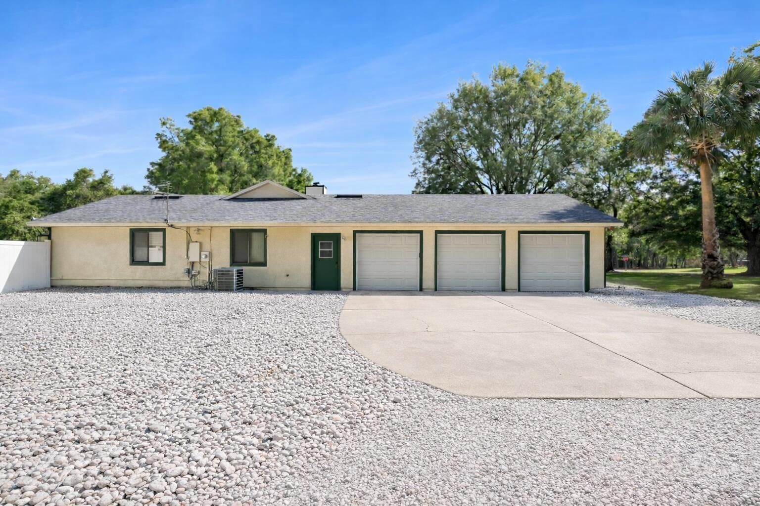A single-story house with a three-car garage, a concrete driveway, and a gravel front yard — 3501 Hill Stream Avenue, FL 32712, FL