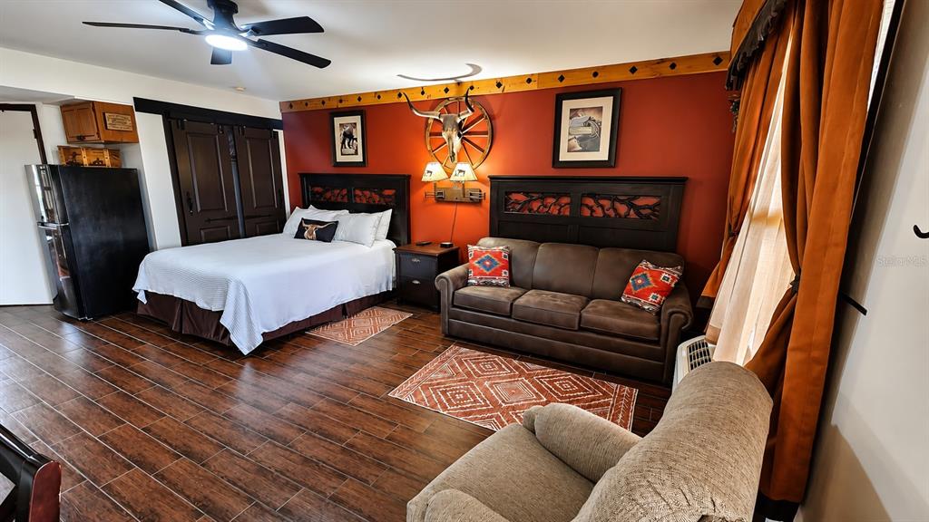 A bedroom features a bed, a brown sofa, a recliner, and western-themed decor — 3200 RIVER RANCH BOULEVARD UNIT 170, RIVER RANCH, FL