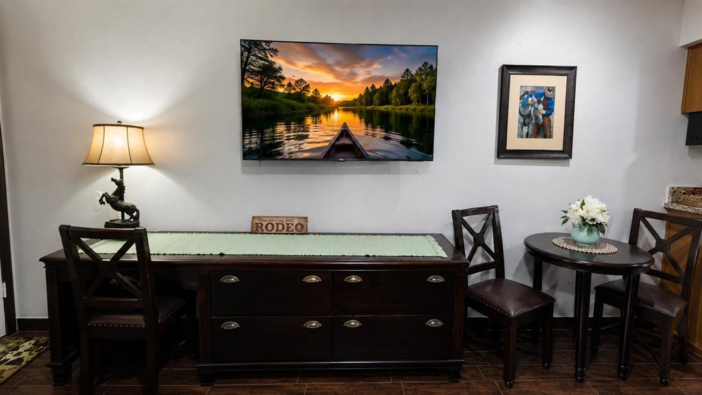 A room features a dark wood desk, a small dining table, and wall-mounted television — 3200 RIVER RANCH BOULEVARD UNIT 170, RIVER RANCH, FL