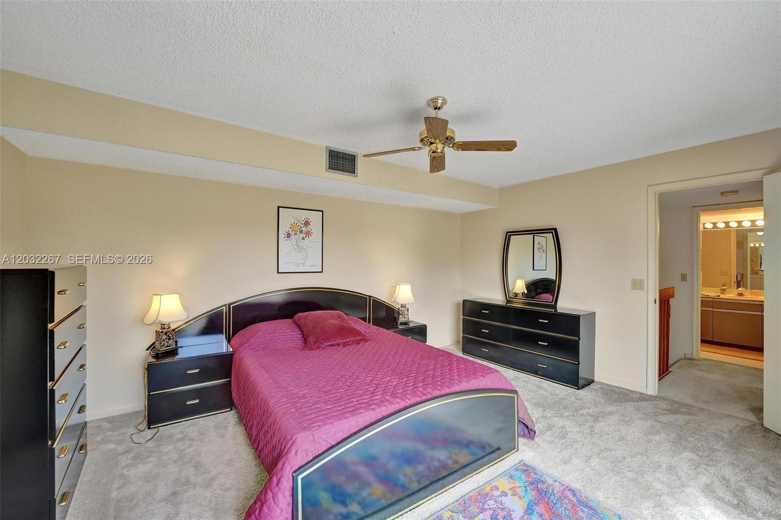 A bedroom features a magenta bed, black furniture, a ceiling fan, and carpeted flooring — 11100 SW 15th Mnr, Davie FL 33324, DAVIE, FL