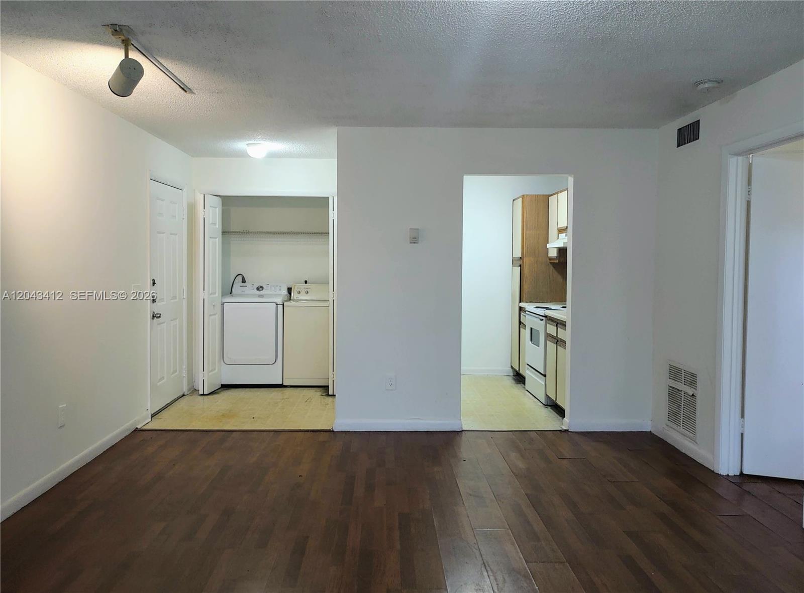 This room features wood-look flooring, a laundry closet, and an open doorway to the kitchen — 4241 W Mcnab Rd # 27, Pompano Beach FL 33069, POMPANO BEACH, FL
