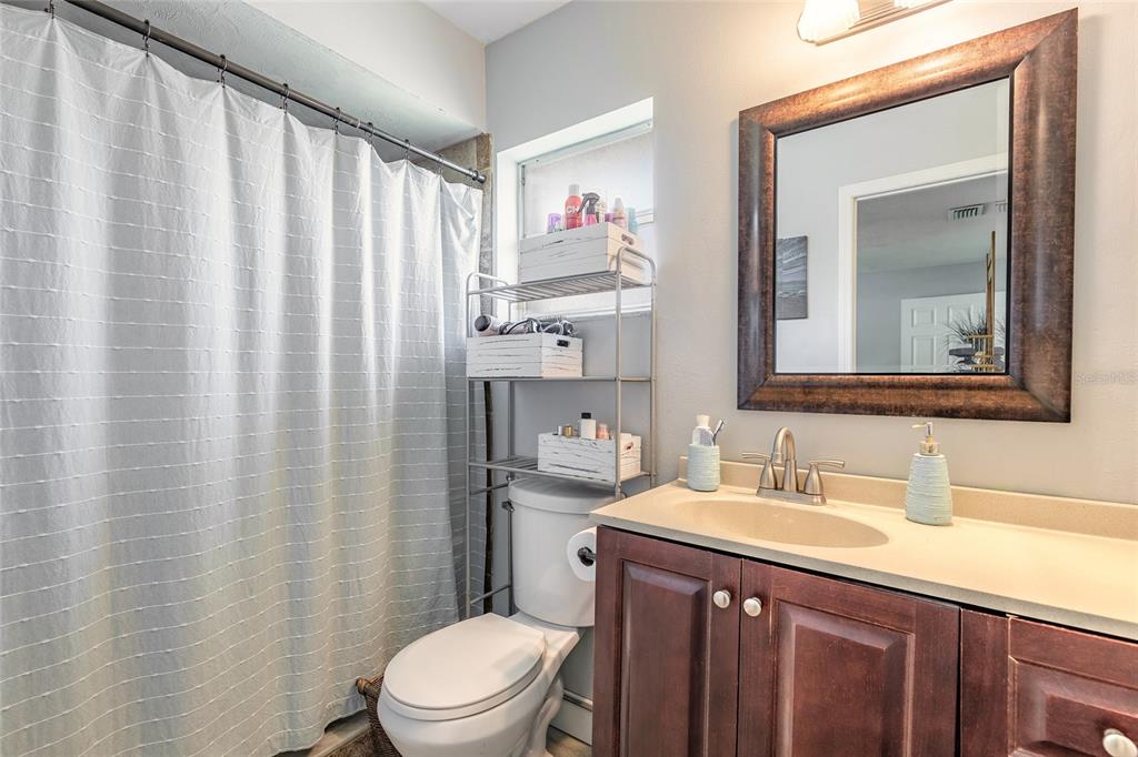 A bathroom features a vanity with a dark wood cabinet, a mirror, and a toilet — 2616 WOODLAND DRIVE, EDGEWATER, FL