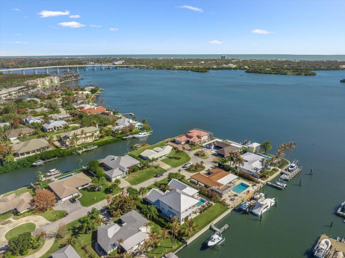 An aerial view shows waterfront houses with private docks along a canal and bay — 2 Seahorse Lane, Vero Beach FL 32960, VERO BEACH, FL