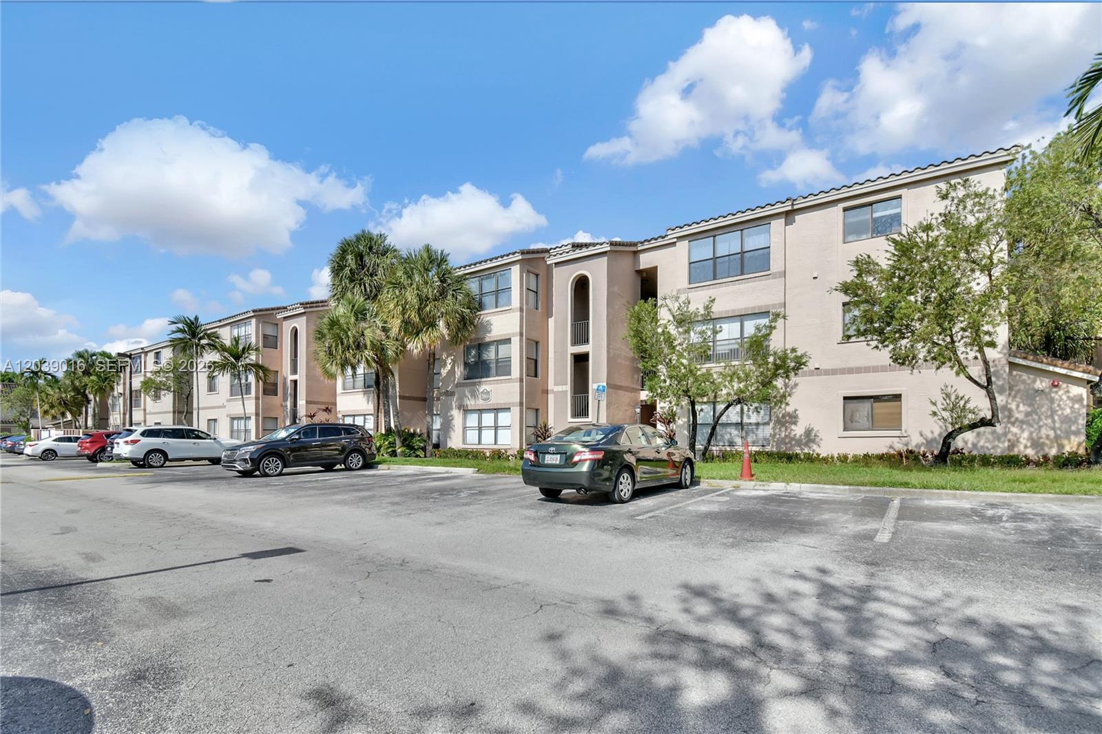 A multi-story apartment building with a parking lot in the foreground under a blue sky — 2866 S University Dr # 5105, Davie FL 33328, DAVIE, FL
