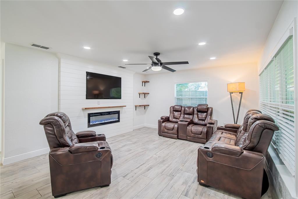 A living room features a shiplap fireplace wall, wood-look tile flooring, and brown leather recliners — 640 ORANGE VALLEY CIRCLE, LAKELAND, FL