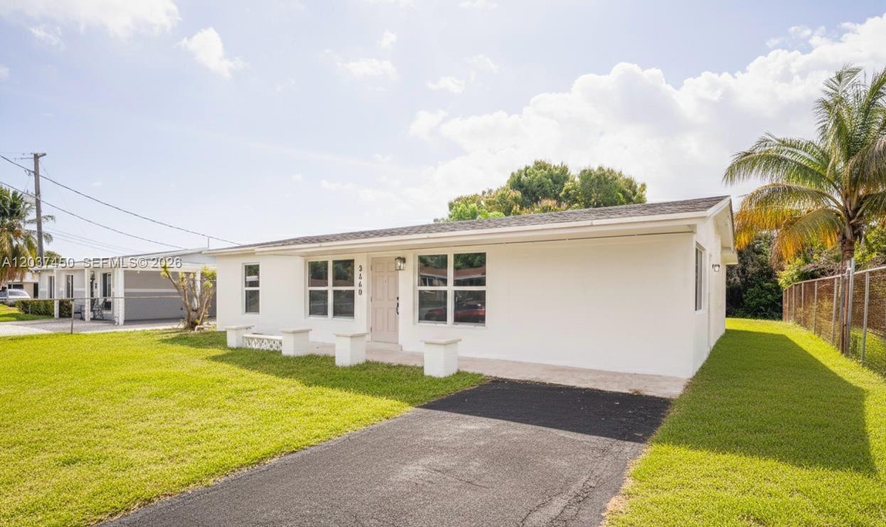 A white single-story house features a front lawn, a paved driveway, and a palm tree — 3460 NW 17th St, Lauderhill FL 33311, LAUDERHILL, FL