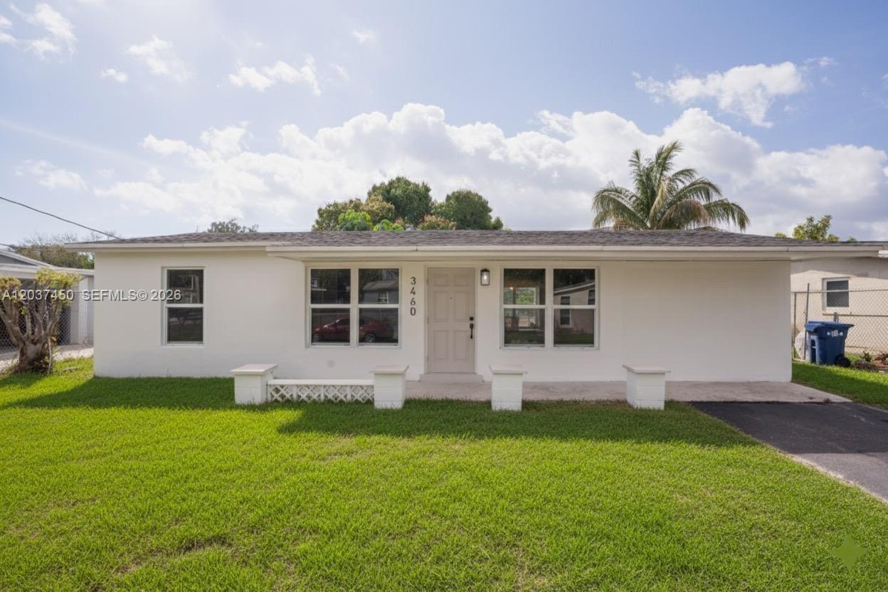 A single-story white house features a front porch with concrete pillars and a grassy lawn — 3460 NW 17th St, Lauderhill FL 33311, LAUDERHILL, FL