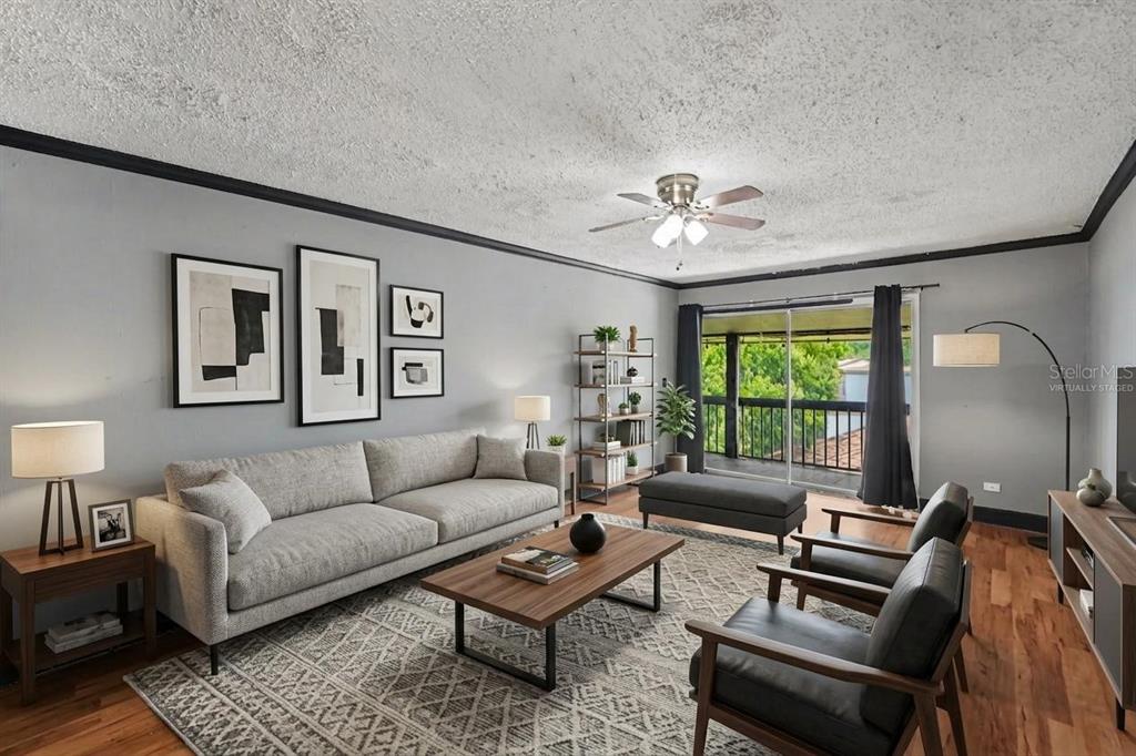 A living room with a grey sofa, two armchairs, a coffee table, and a balcony view — 6308 NEWTOWN CIRCLE UNIT C4, TAMPA, FL