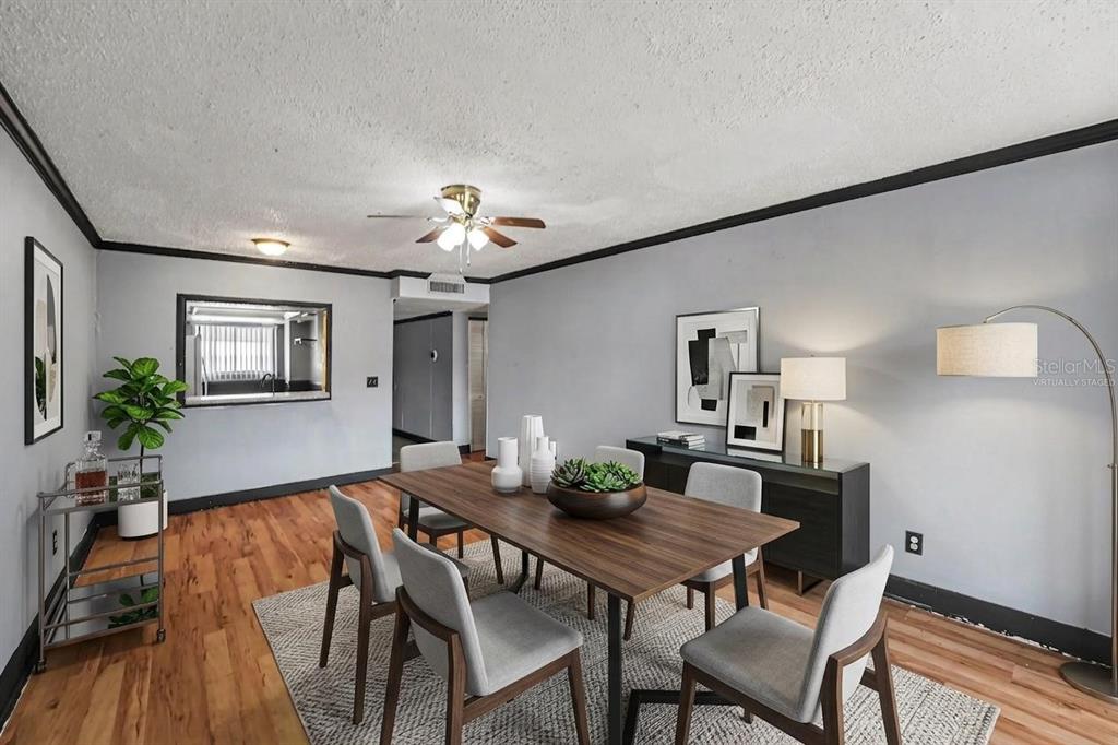 A dining room features a wooden table, gray chairs, a sideboard, and wood-look flooring — 6308 NEWTOWN CIRCLE UNIT C4, TAMPA, FL