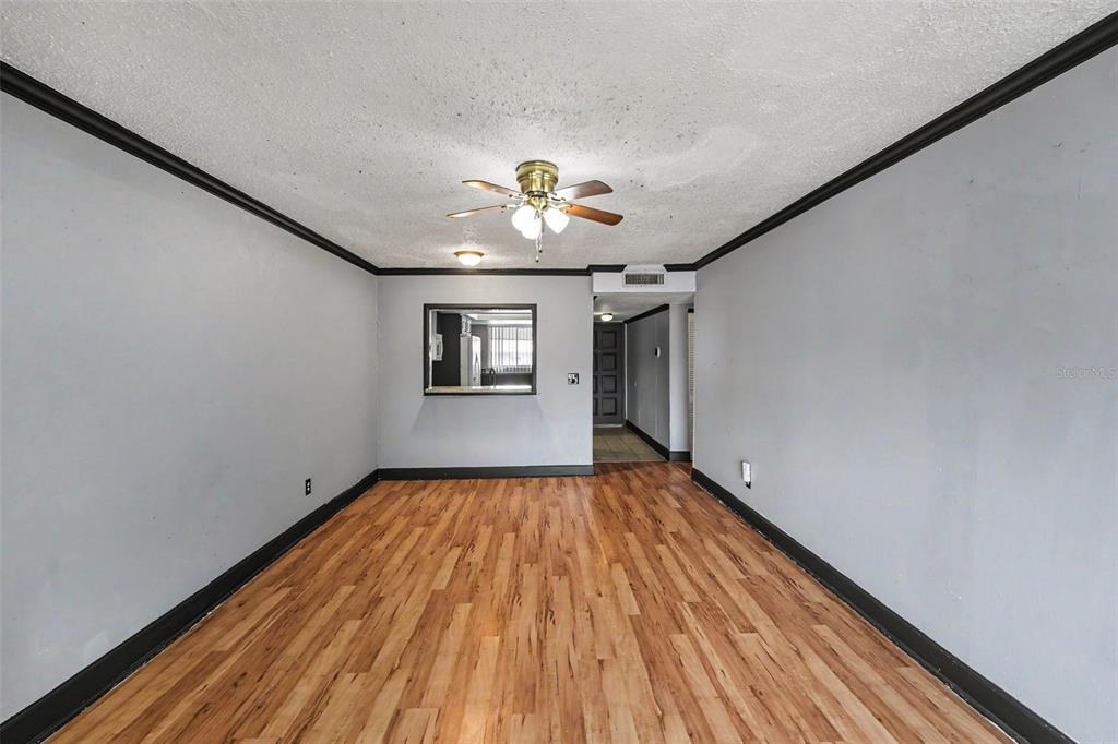 An empty room features gray walls, dark trim, wood-look flooring, and a ceiling fan — 6308 NEWTOWN CIRCLE UNIT C4, TAMPA, FL