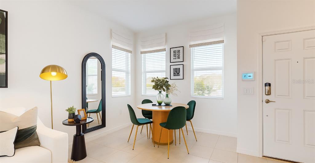 A dining area features a round wooden table, four green chairs, and a floor mirror — 2004 VIEWFINDER STREET, KISSIMMEE, FL