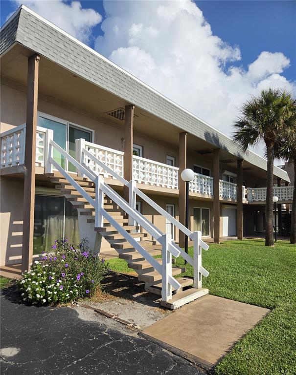 An exterior view of a two-story apartment building with white railings and an outdoor staircase — 3150 N ATLANTIC AVENUE UNIT 4-770, COCOA BEACH, FL