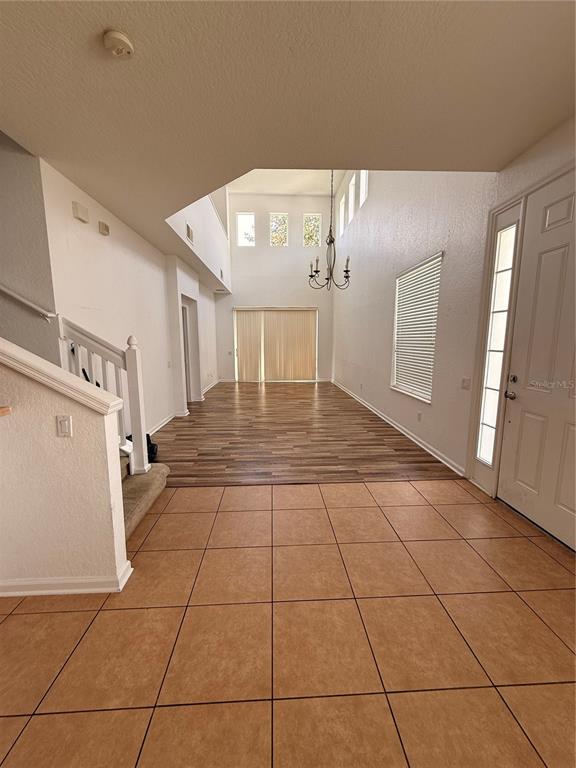 An entryway with tile flooring transitions into a living area with wood-look floors and windows — 1178 SHALLCROSS AVENUE, ORLANDO, FL