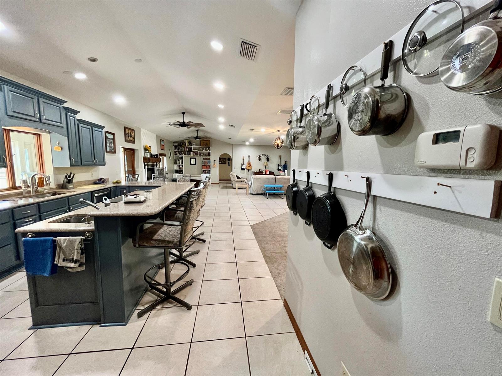 A kitchen with blue cabinets and a breakfast bar opens into a living area — 3046 N Bowden Road, FL 33825, FL