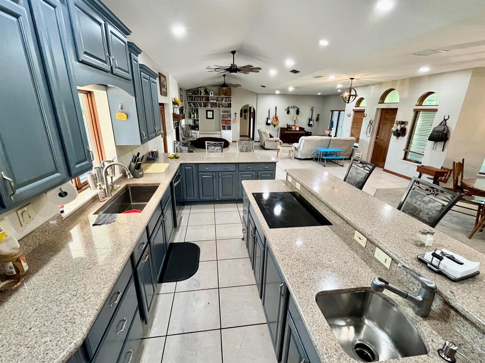 A kitchen with blue cabinets and granite countertops opens into a large living area — 3046 N Bowden Road, FL 33825, FL