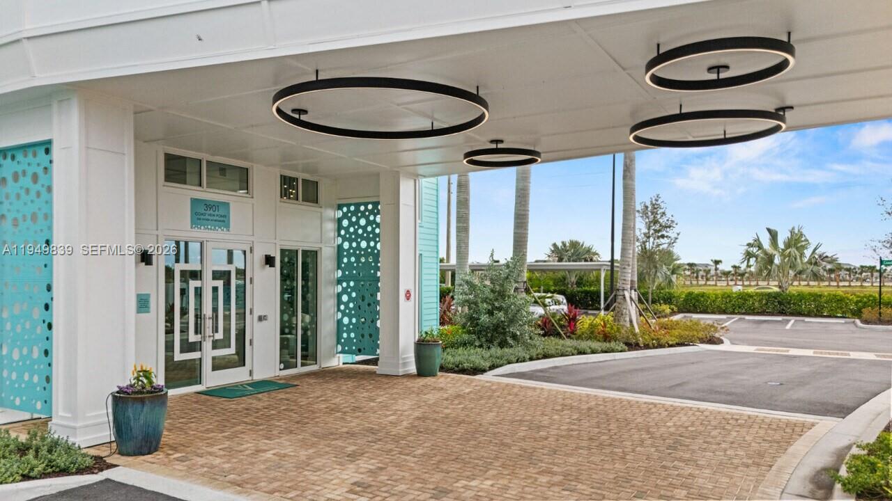 A covered entrance with a brick driveway, modern circular light fixtures, and glass double doors — 3901 Coast View Pointe # A3, Vero Beach FL 32960, VERO BEACH, FL