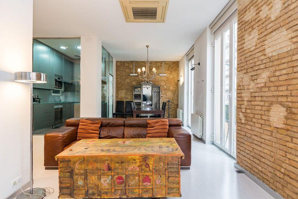 A living room with a leather sofa, painted wooden chest, and exposed brick walls — 26 Carrer Del Mestre Gozalbo, FL