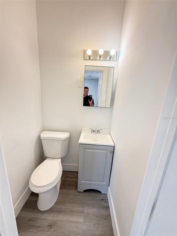 A small bathroom features a white toilet, a gray vanity, and a wall-mounted mirror — 14060 NW 19TH AVENUE, OPA LOCKA, FL