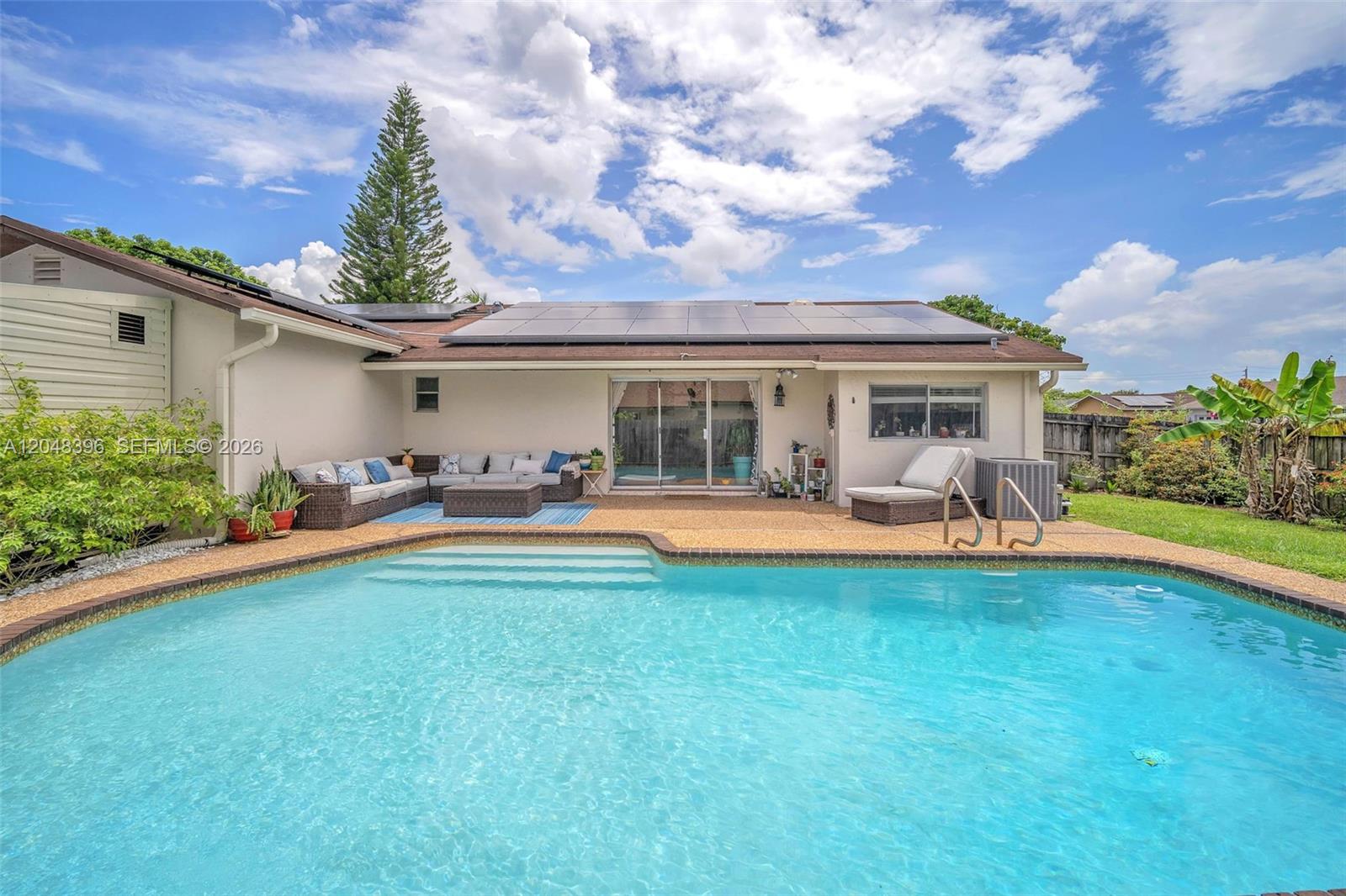 A backyard features a swimming pool, a patio with outdoor furniture, and solar panels installed — 2401 NW 110th Ter # 2401, Sunrise FL 33322, SUNRISE, FL