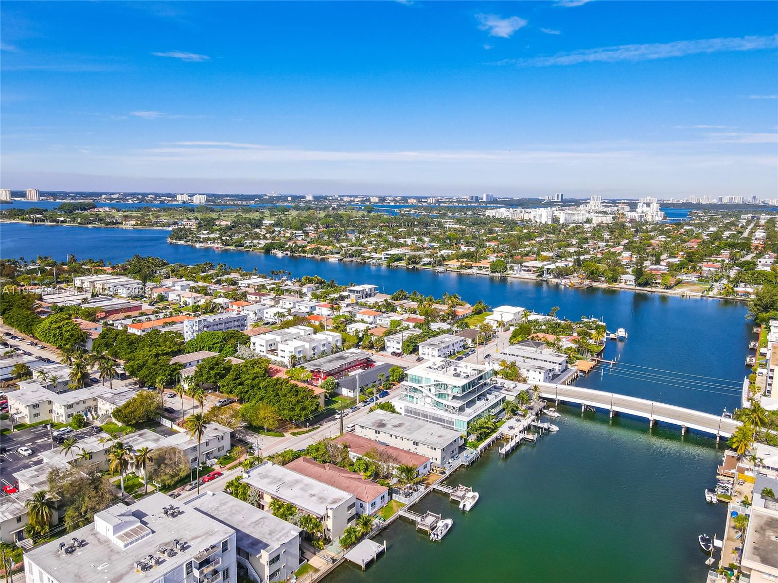 An aerial view shows a waterfront neighborhood with a bridge, residential buildings, and boats — 8335 E Crespi Blvd # 4, Miami Beach FL 33141, MIAMI BEACH, FL