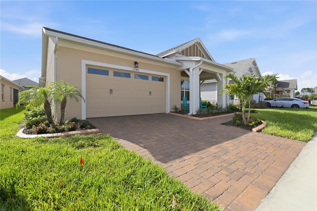 A single-story house with a beige exterior, a two-car garage, and a paver driveway — 2789 SOUTHLAND STREET, ST CLOUD, FL