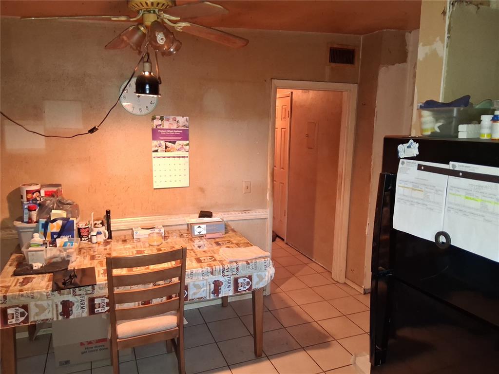 A dining area features a table with a patterned tablecloth, a ceiling fan, and tile flooring — 1208 BEATRICE DRIVE, ORLANDO, FL