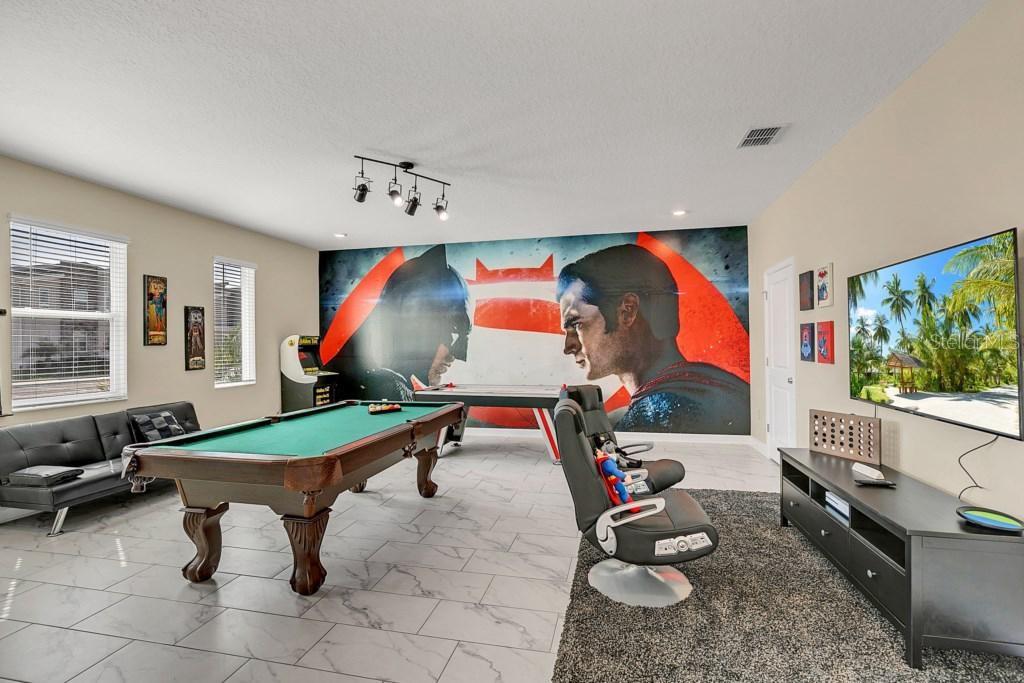 A game room features a pool table, air hockey table, large mural, and television — 4541 TARGET BOULEVARD, KISSIMMEE, FL