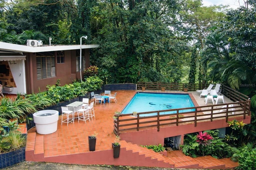 An outdoor patio features a swimming pool, dining area, and lush tropical landscaping — Beverly Hills 1, SAN JUAN, PR