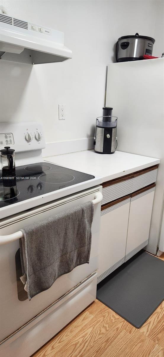 A kitchen features a white electric stove, a countertop with a juicer, and white cabinets — 2000 NE 135th St # 806, North Miami FL 33181, NORTH MIAMI, FL