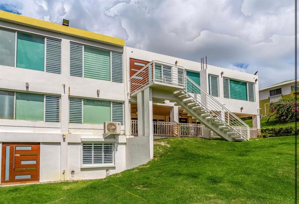 A two-story white building with an exterior staircase leading to an upper-level balcony — Calle 2 CARRETERA OESTE 169 UNIT 169, LUQUILLO, PR
