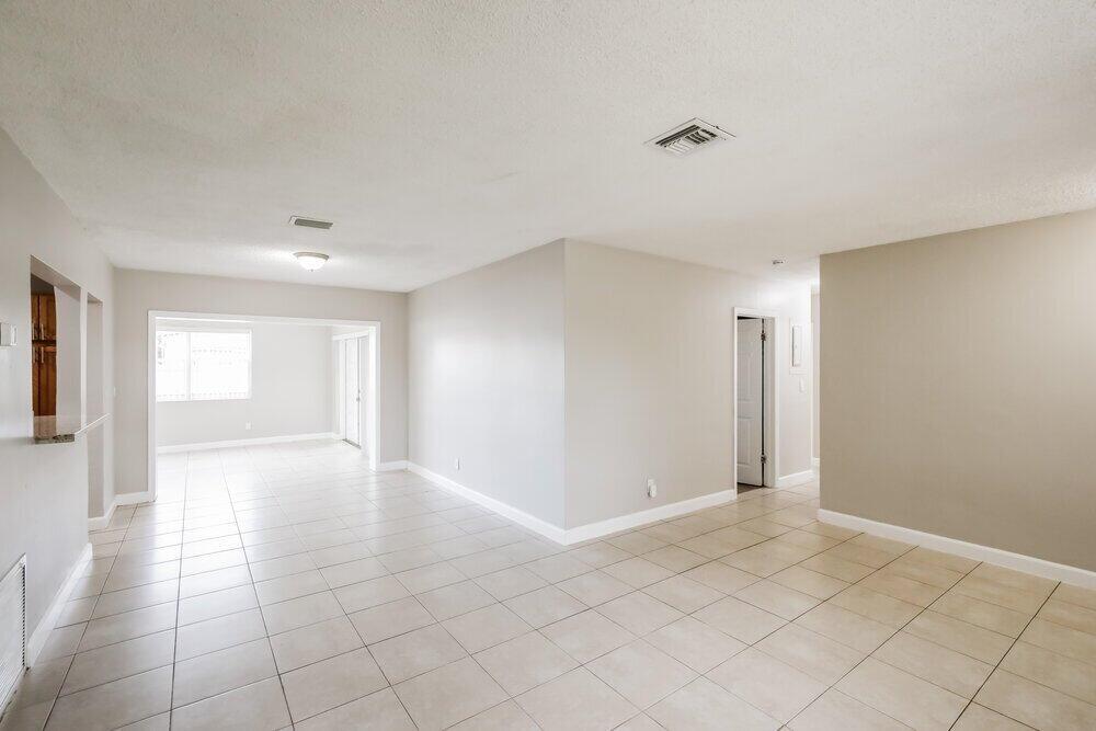 An open-concept living area features light-colored tile flooring, neutral walls, and a recessed ceiling light — PEMBROKE PINES, FL