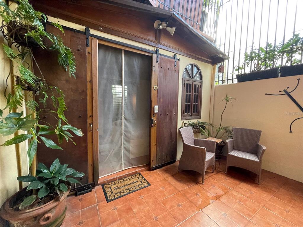 A hallway with peach walls, arched wooden doors, and patterned tile flooring — 456 CALLE SALDAÑA, SAN JUAN, PR