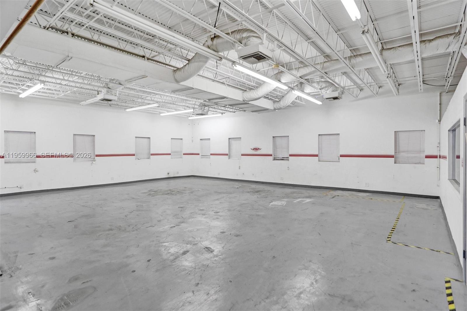 An empty industrial warehouse space features white walls, exposed ceiling beams, and concrete flooring — 1900 NW 32nd St, Pompano Beach FL 33064, POMPANO BEACH, FL